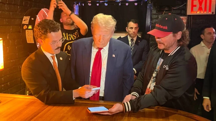 Image shows Mr. Trump being guided on paying for hamburgers with Bitcoin